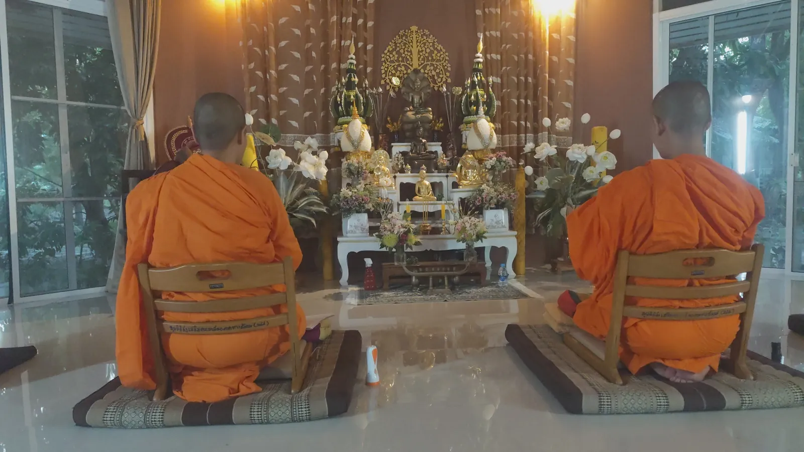 Ranní obřad dvou mnišek před oltářem v centru The Vijjaram Dhamma Center